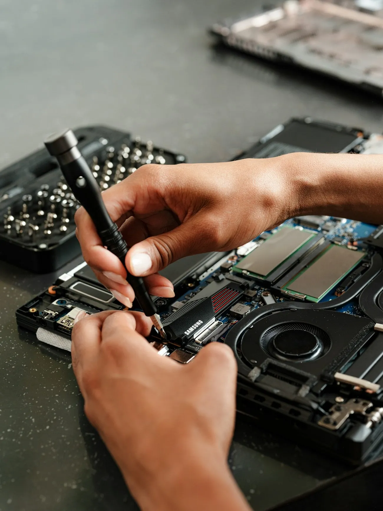A LaptopHaber engineer using a precision probe on the internals of an opened laptop to trace a shorted power rail